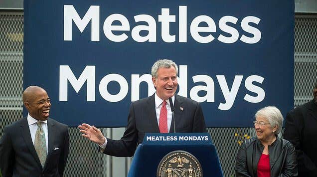 Mayor Bill de Blasio giving a speech in front of a "Meatless Mondays" banner