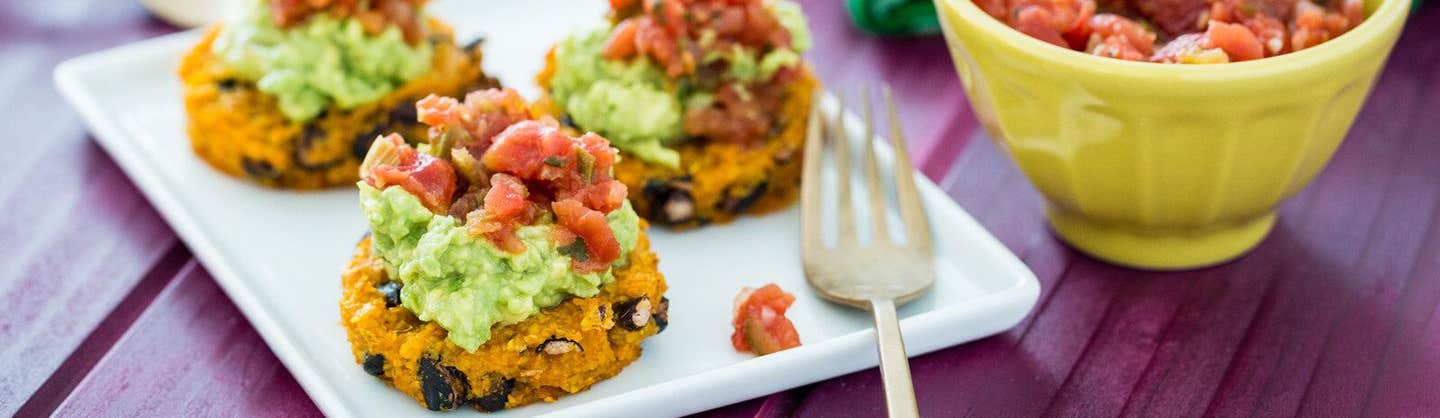 Three Polenta–Black Bean Medallions with Spicy Salsa on a white rectangle plate with a fork resting on the side