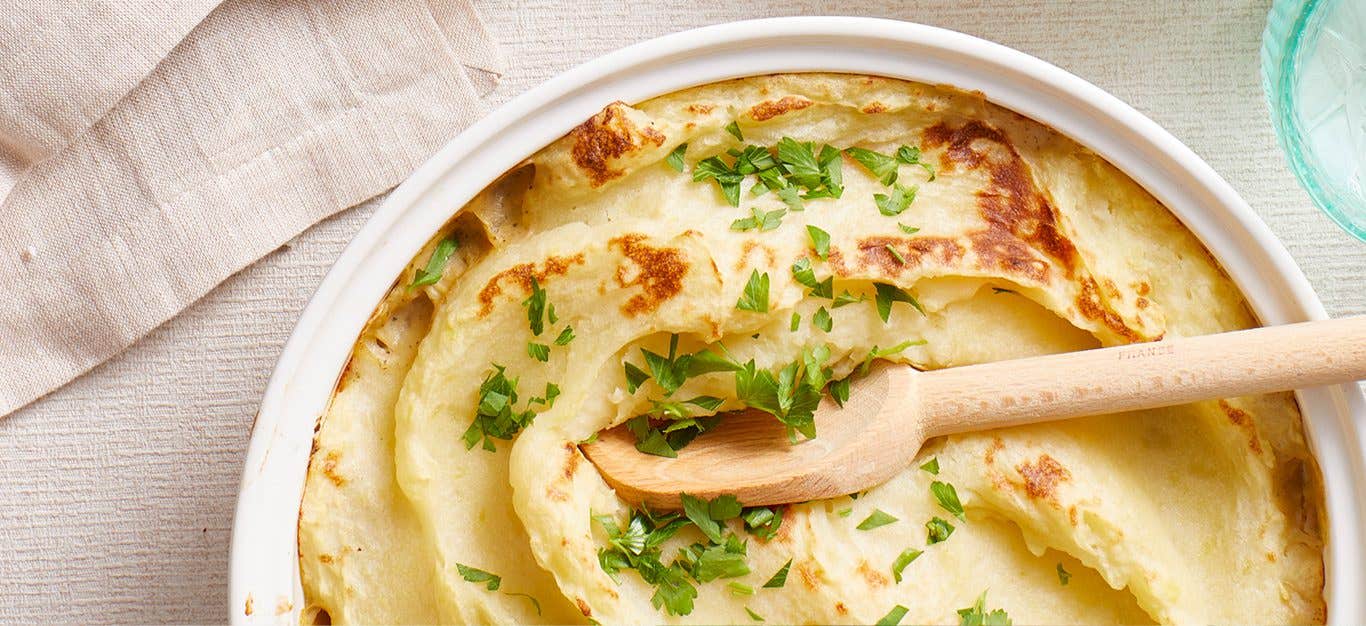 Budget-Friendly Shepherd’s Pie in a white bowl with a wooden spoon