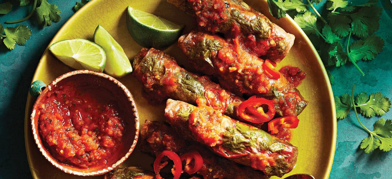 Air-Fried Southwest Spring Rolls on a yellow plate with lime wedges and a small bowl of salsa