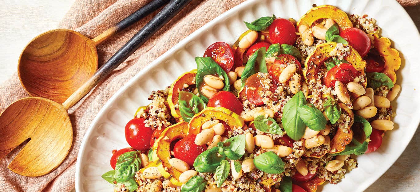 Balsamic-Roasted Delicata Squash Salad on a white serving platter with wooden serving spoons