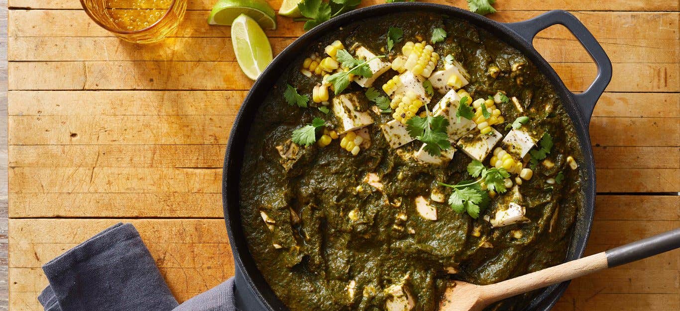 Beet Greens and Spinach Saag with Tofu in a skillet on a wood tabletop