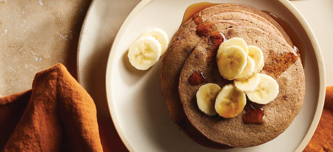 Chocolaty Black Bean Pancakes with sliced bananas on a cream colored plate