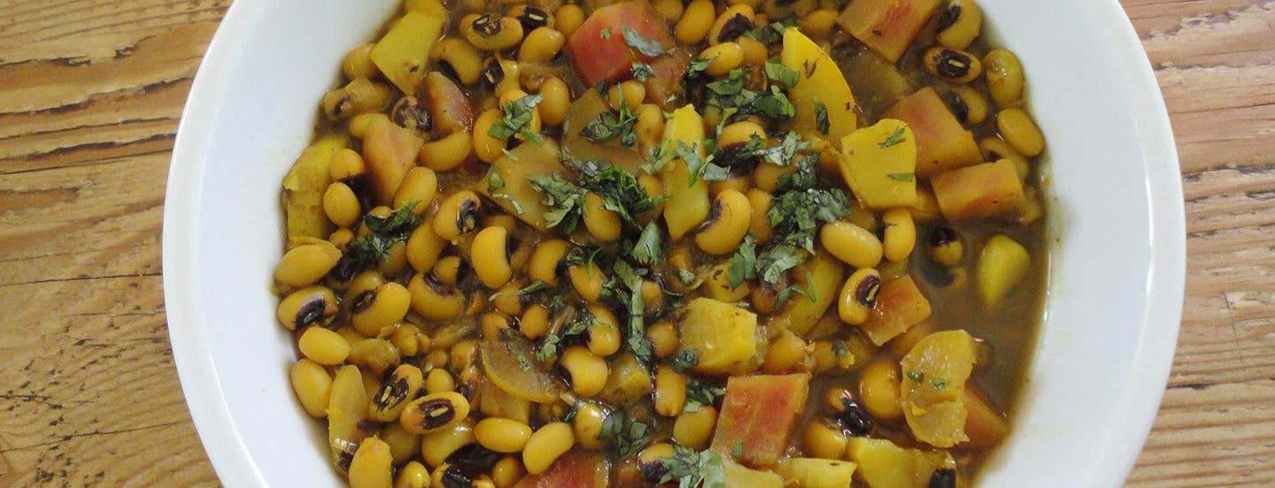 Top-down view of Black-Eyed Pea Stew in a white bowl on a wooden surface