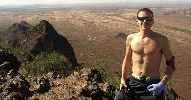 Runner Brandon Frye stands on a rocky overlook on a sunny day