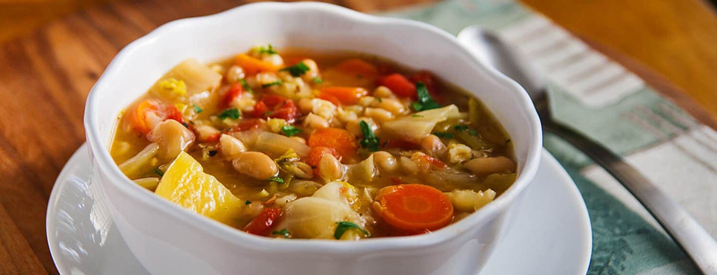 Irish White Bean and Cabbage Stew in a white bowl sitting on a white plate