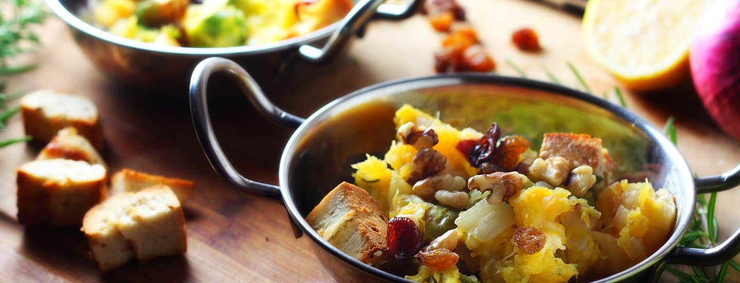 One-Pot Squash and Brussels Sprouts Panzanella with Dried Cherries on a wooden chopping board with croutons