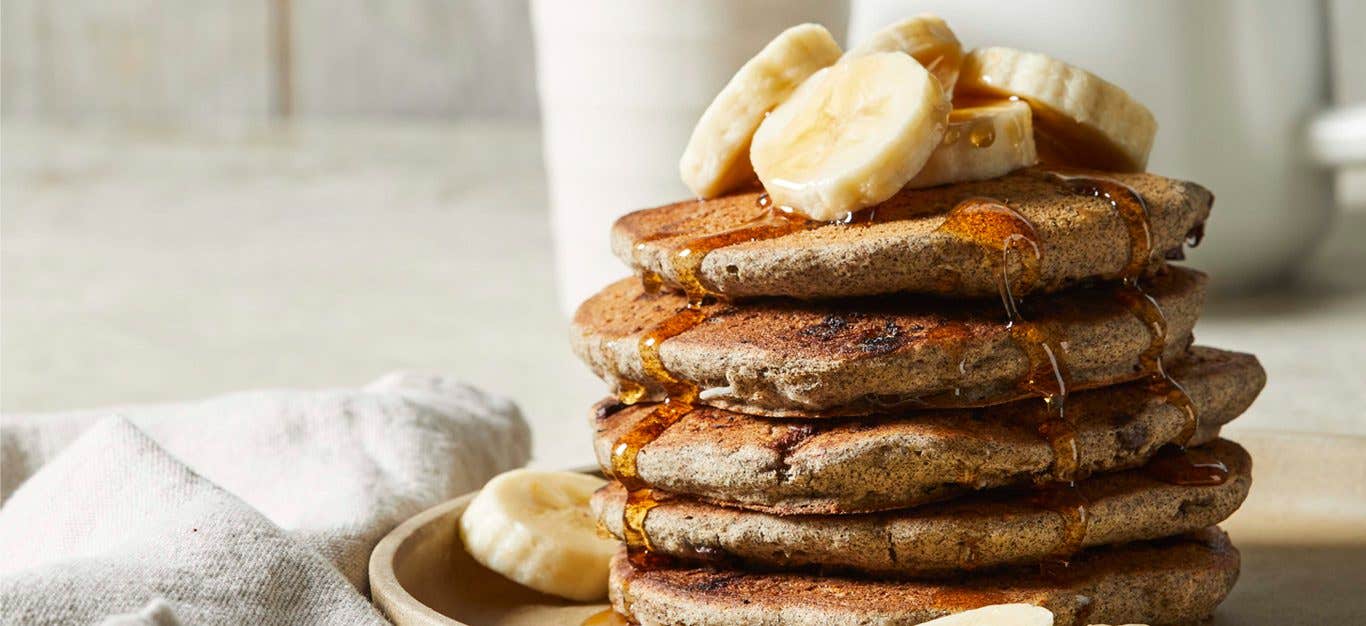 Gluten-Free Chocolate Chip Pancakes made with buckwheat flour and drizzled with maple syrup and banana slices