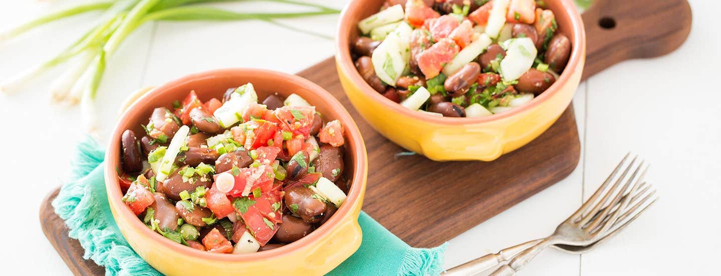 Two bowls of Fava Bean Salad on a wooden chopping board