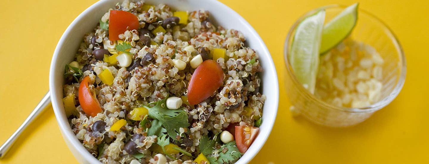 Fiesta Quinoa Salad in a white bowl with lime wedges in a smaller bowl