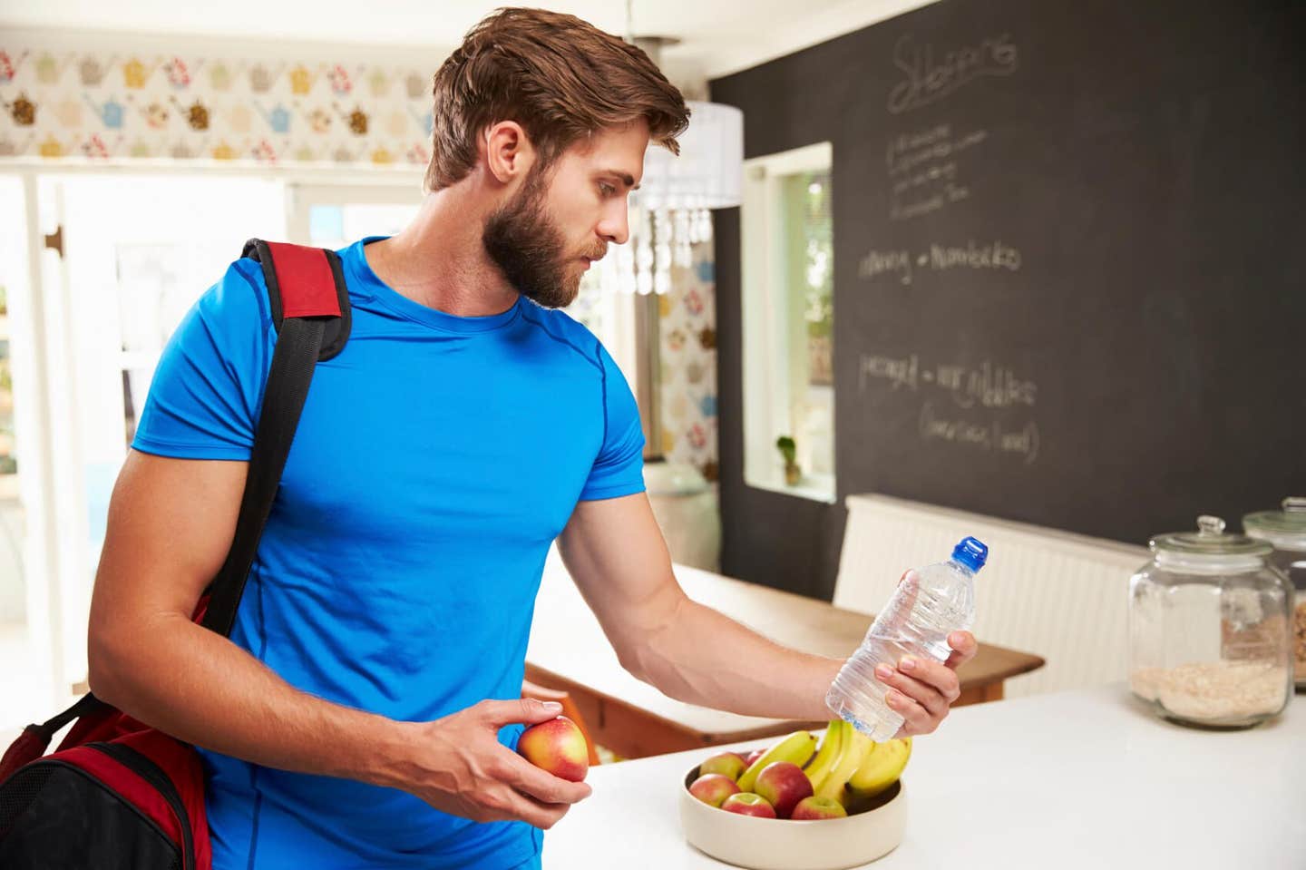 Man Wearing Gym Clothing Choosing Fruit From Bowl