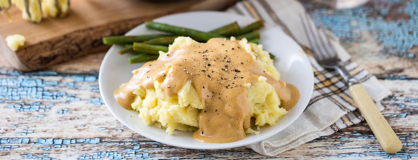 Heather's Garlic Mashed Potatoes and Creamy Golden Gravy on a plate with asparagus spears