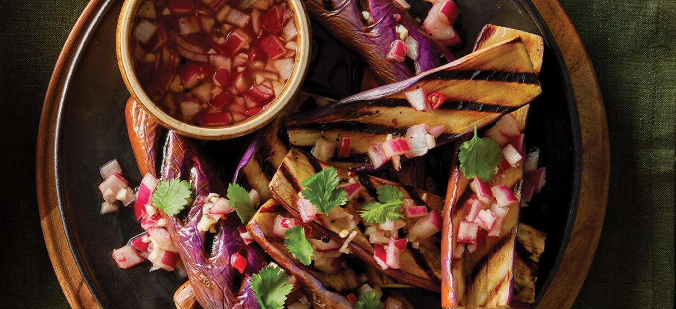 Grilled Chinese Eggplant with Spiced Vinegar Sauce on a dark grey plate