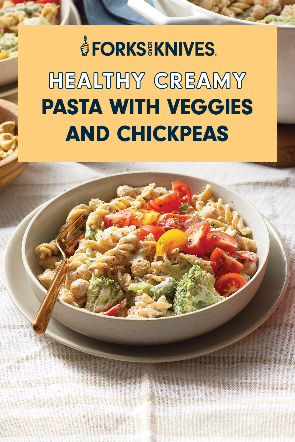 A bowl of creamy pasta, featuring cherry tomatoes and broccoli. Text above reads, "Healthy Creamy Pasta with Veggies and Chickpeas"