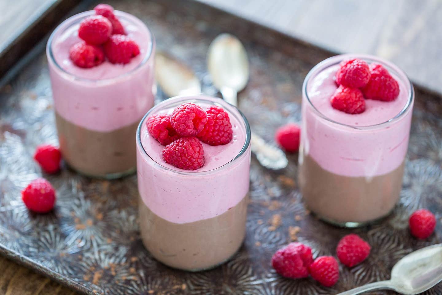 Chocolate Raspberry Parfaits on a metal baking tray with raspberries strewn between