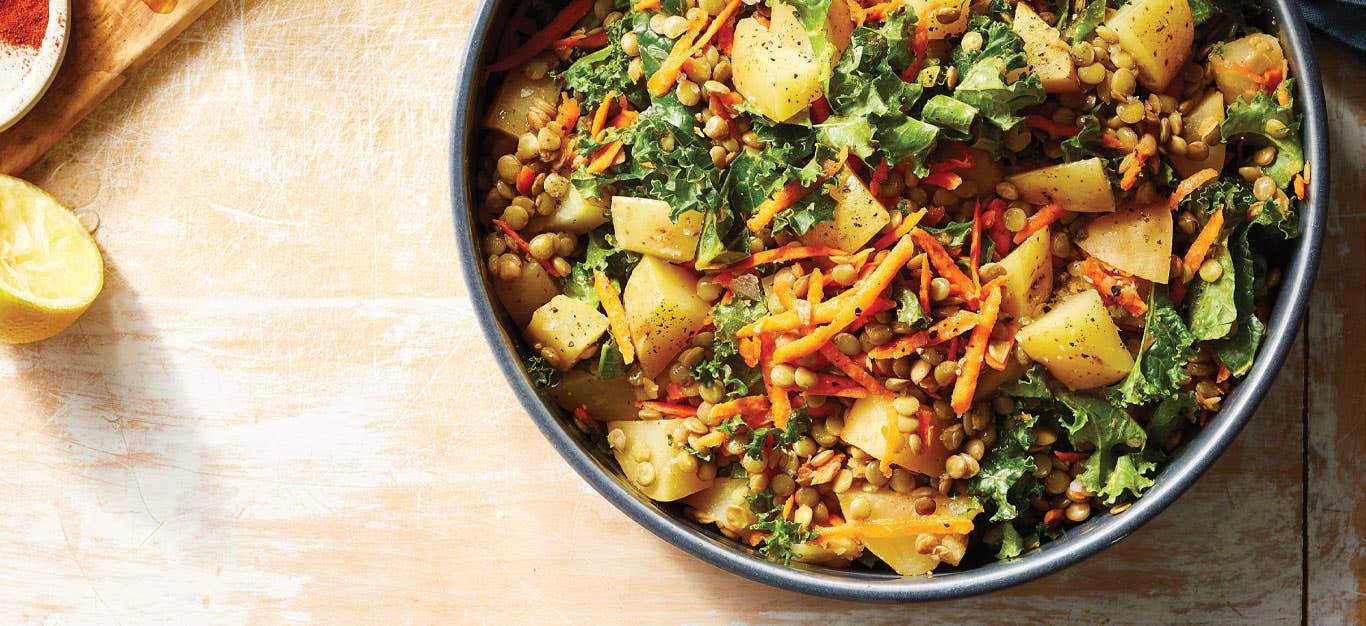 Kale and Lentil Salad with Potatoes in a gray ceramic bowl against a light wood tabletop