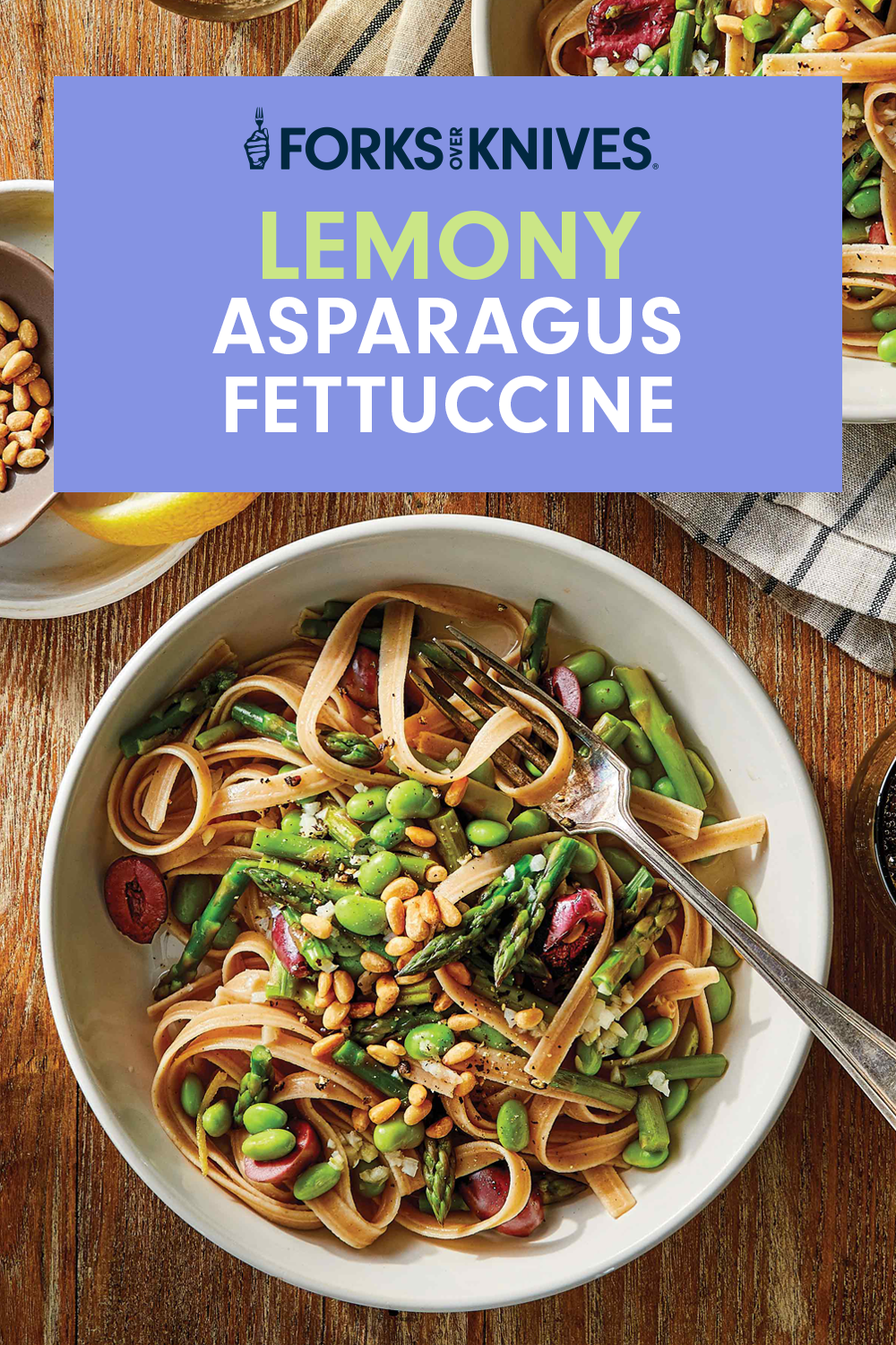 Lemony Asparagus Fettuccine in white bowls with metal forks against a wood tabletop.