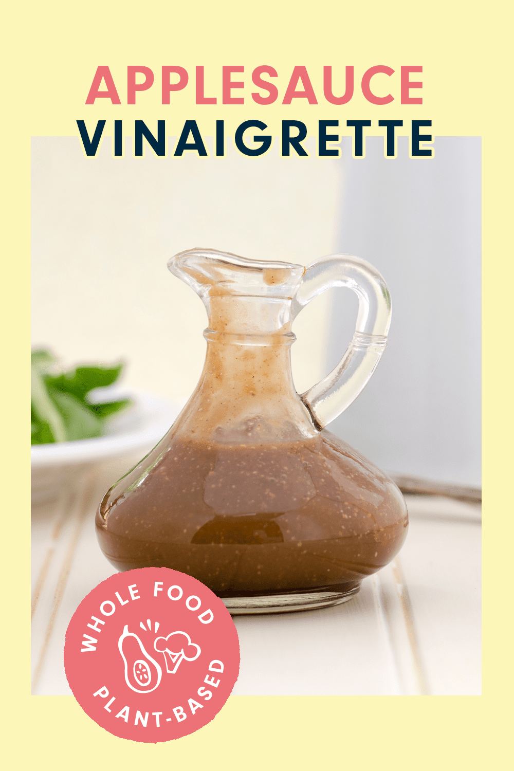 A stylish glass jug on a cream countertop with a heading that reads, "Applesauce Vinaigrette"