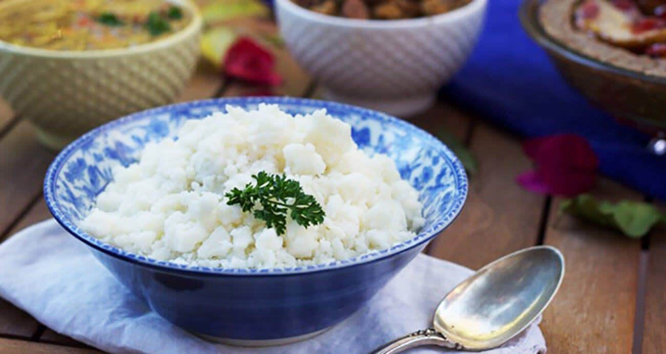 Mashed potatoes in a blue bowl on a white cloth napkin