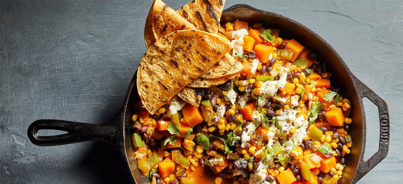 Mexican Hash with Lime Crema in a cast iron skillet with tortillas