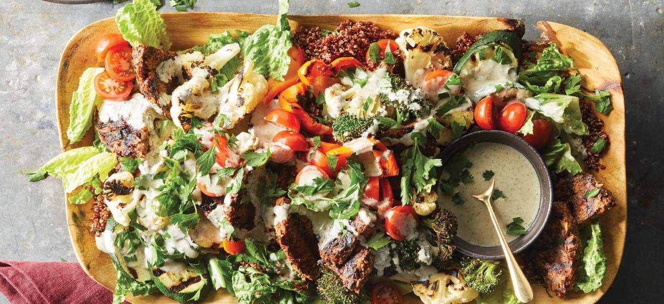 Vegan Mixed Grill Platter on a wooden tray with a small bowl of ranch dressing on the righthand side of the platter