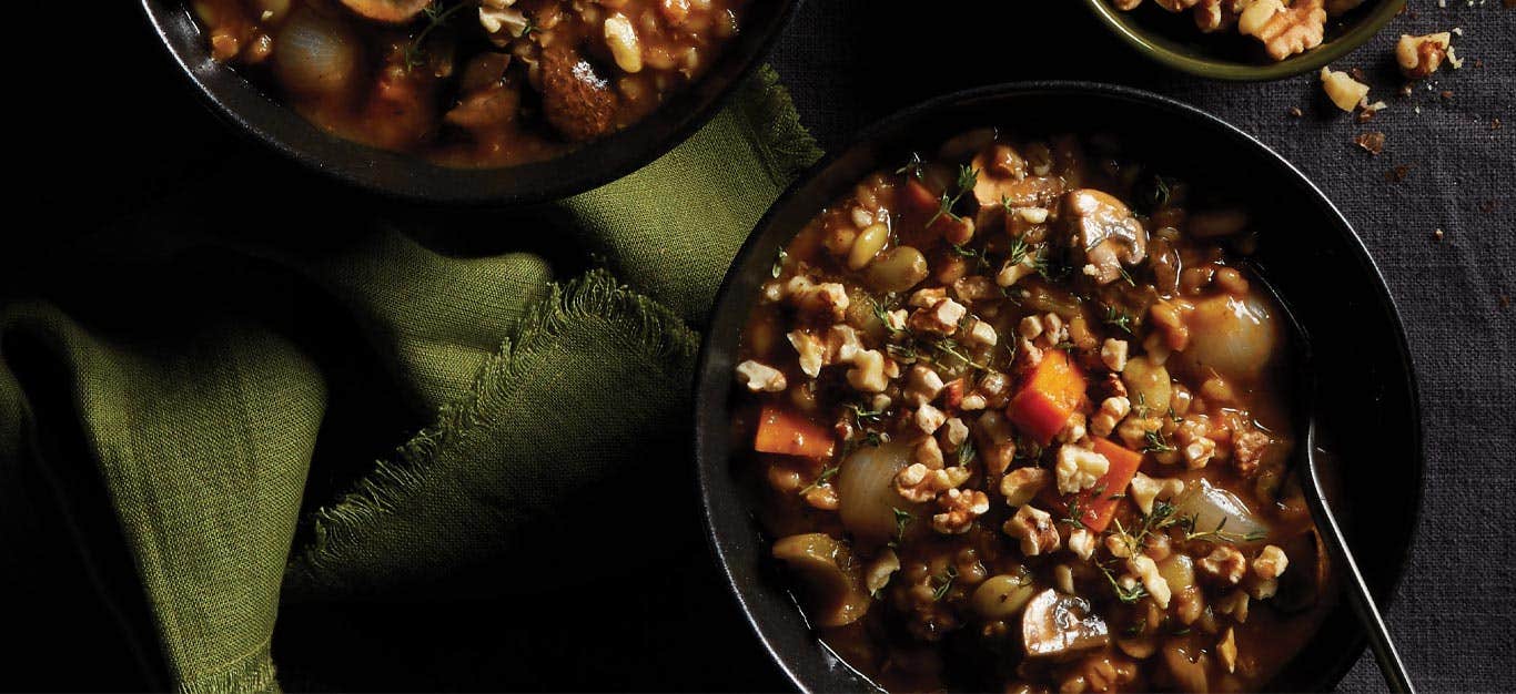 Instant Pot Mushroom-Barley Stew in black bowls with green cloth napkins