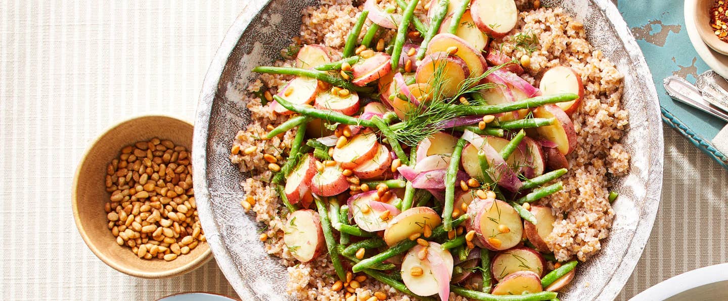 A bowl of cooked bulgur wheat with green beans, new potatoes, and mustard vinaigrette