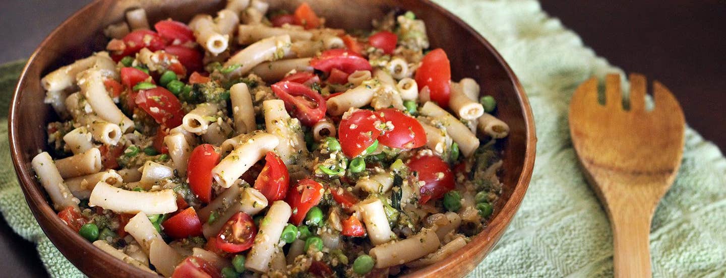 Pasta Primavera in a wooden serving bowl with a wooden serving spoon