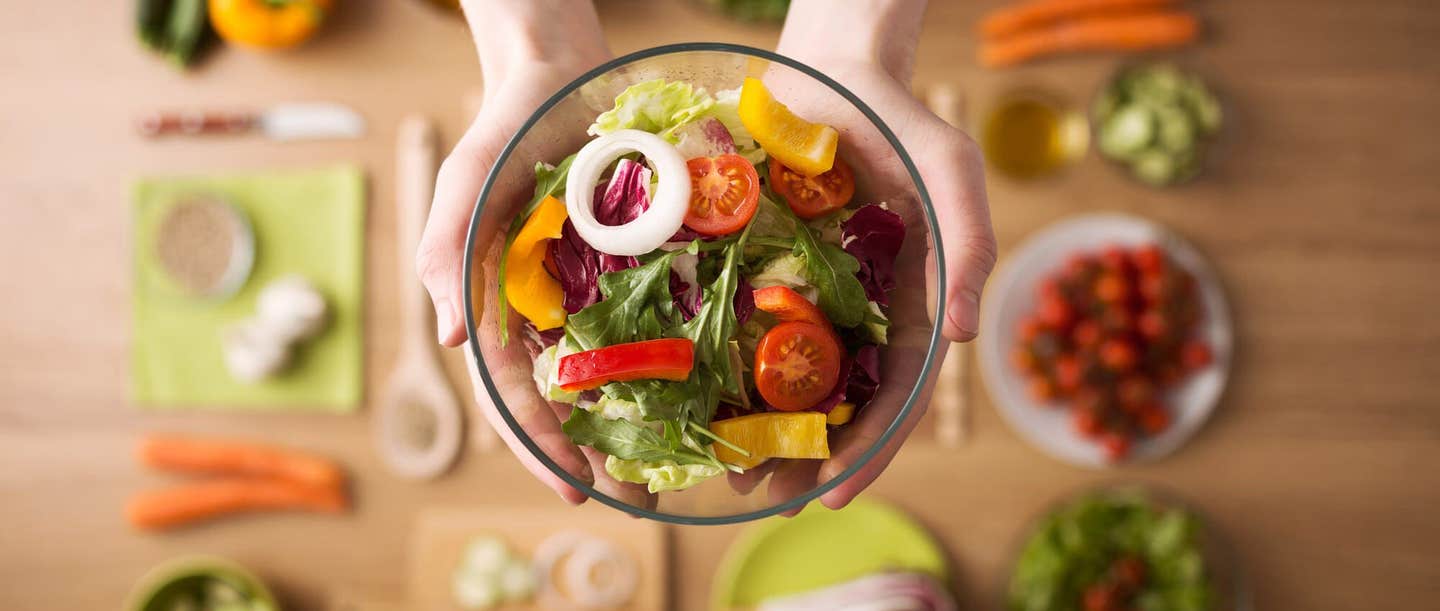 Hands outstretched holding healthy fresh homemade salad