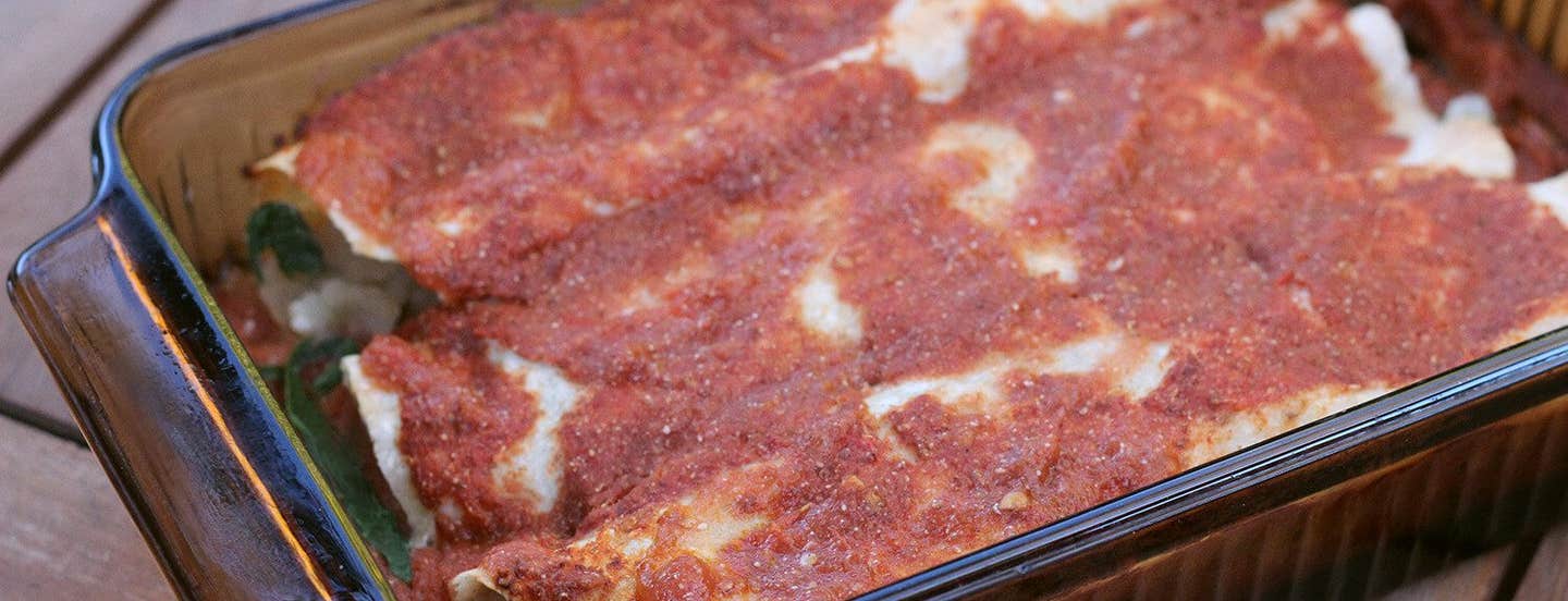 A glass casserole dish filled with three Plant-Based Potato Enchiladas