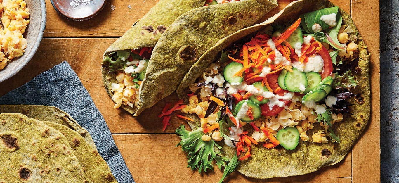 Chickpea Wraps with Homemade Spinach Tortillas on a wood tabletop