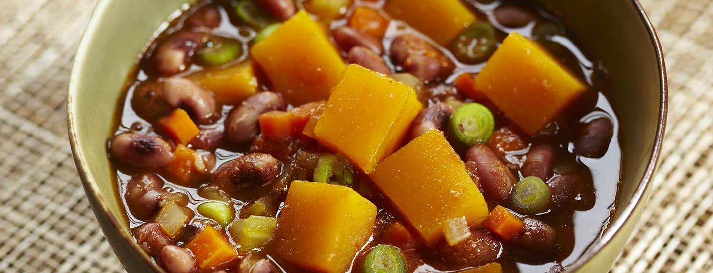 A close-up of Pumpkin and Anasazi Bean Stew in a green bowl