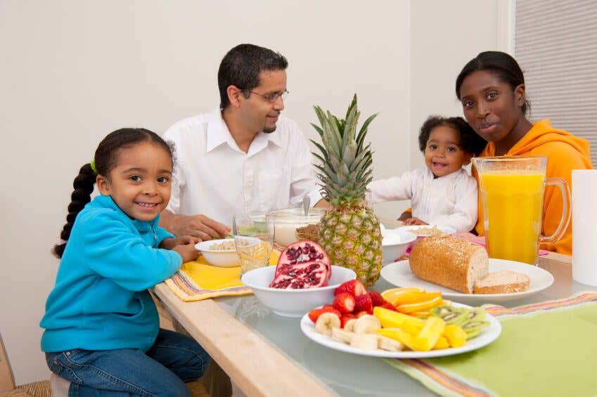 A mixed African American and Hispanic family at the dinner table eating