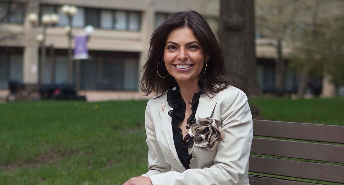 Dr. Saray Stancic sitting on a park bench in the city