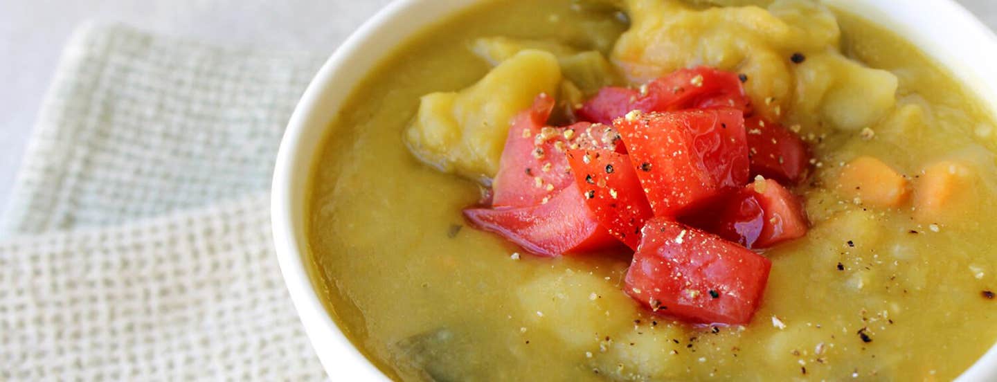 A close up of Split Pea & Yam Soup in a white bowl on a white placemat