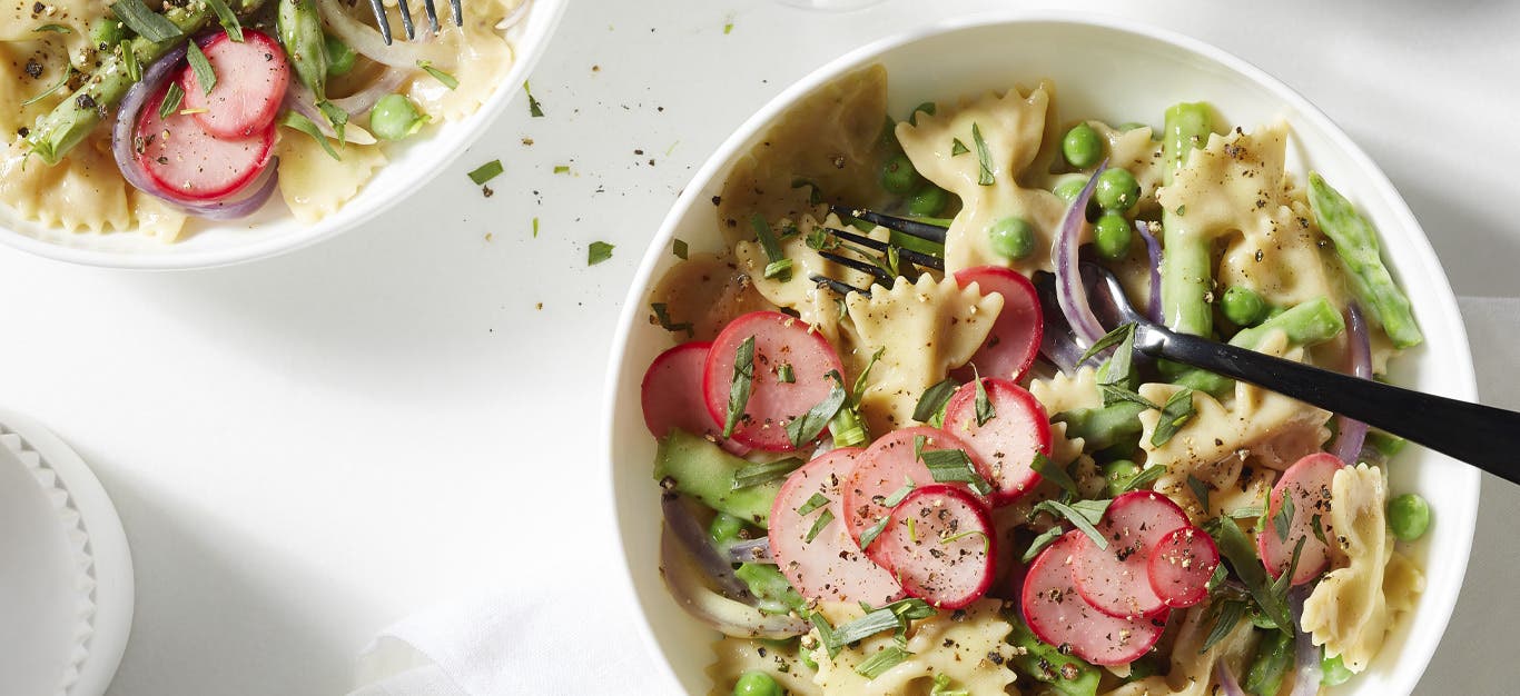 Spring Veggie Mac and Cheese with Vegan White Cheddar Sauce in white bowls