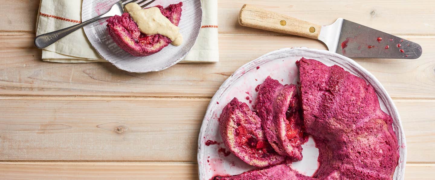 Summer Pudding with Fresh Berries and Lavender Cashew Cream on a round platter with one serving on a small plate