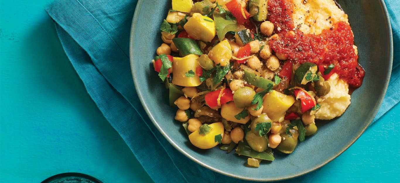 Mediterranean Pepper and Squash Hash with Creamy Polenta in a blue ceramic bowl against a teal background