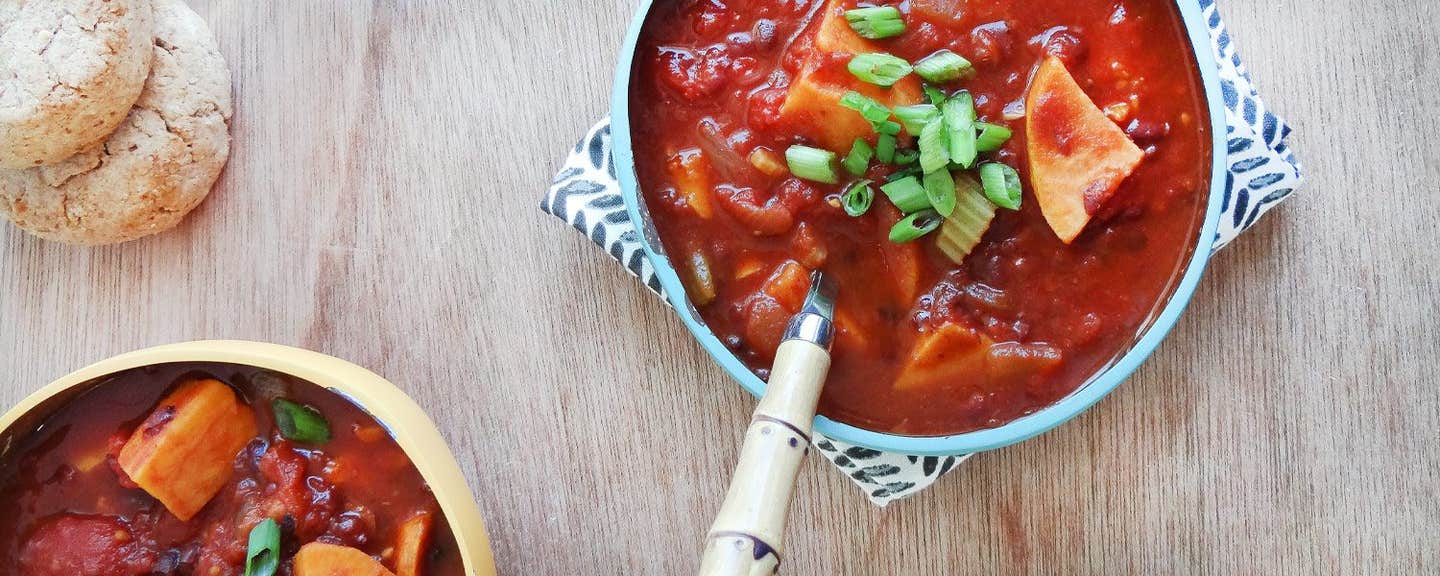 Two bowls of Smoky Chili with Sweet Potatoes garnished with sliced green onions