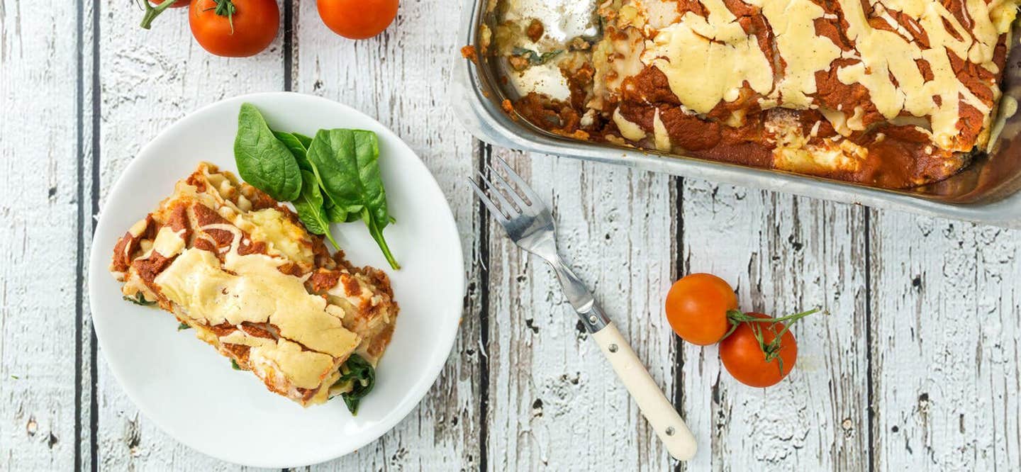 A serving of Sweet Potato Lasagna next to a casserole dish with one serving removed