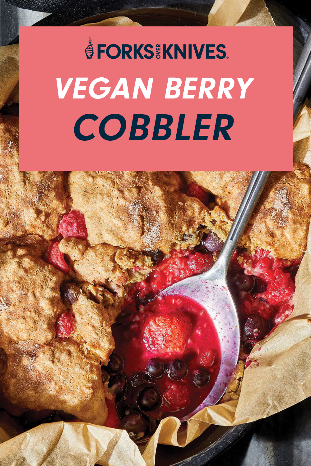 A closeup of a luscious dish of Bursting with Berries Cobbler, with a spoon resting in the dish. A title card reads, "Vegan Berry Cobbler"