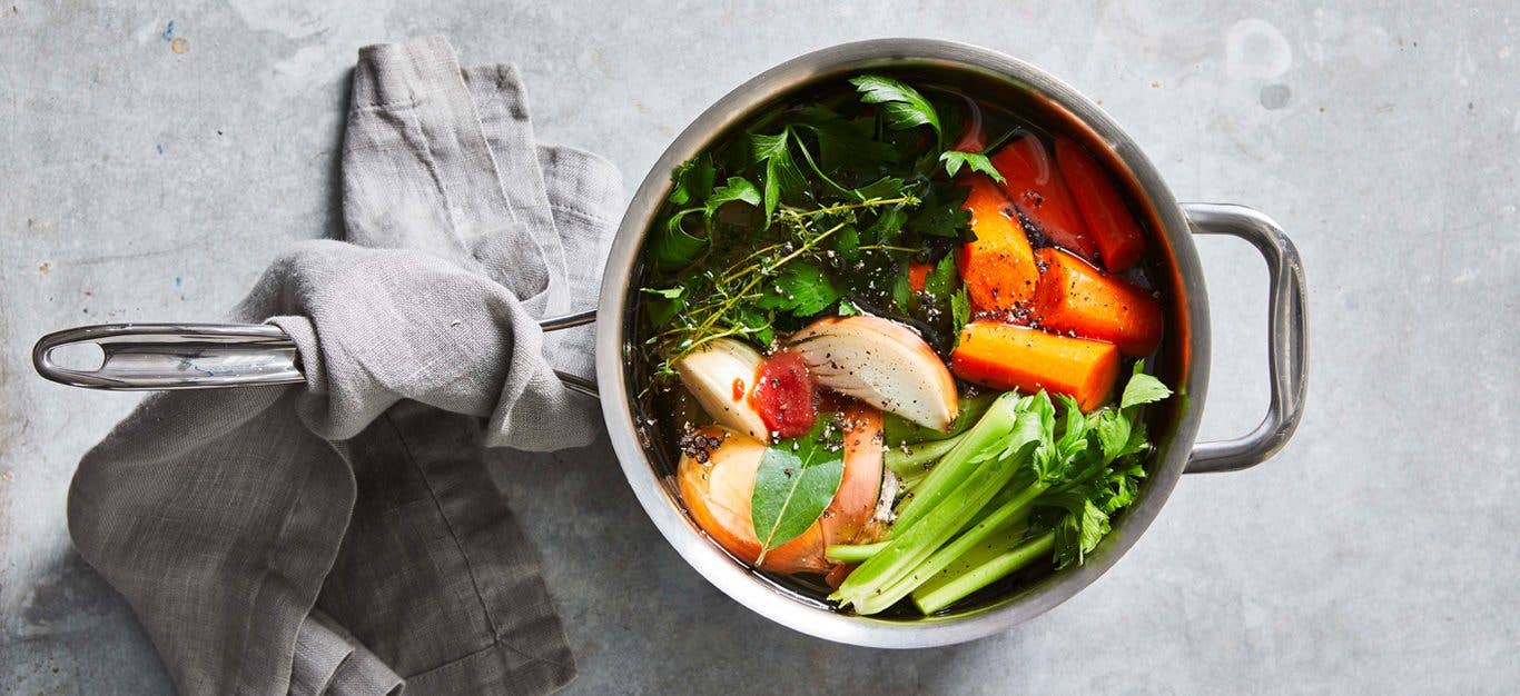 https://www.forksoverknives.com/uploads/Vegetable-Broth-full-of-carrot-chunks-celery-an-onion-wedge-and-fresh-herbs-in-a-medium-silver-pot-on-a-gray-table-with-a-gray-cloth-wrapped-around-the-pot-handle.jpg?auto=webp&auto=webp&optimize=high&quality=70&width=1440