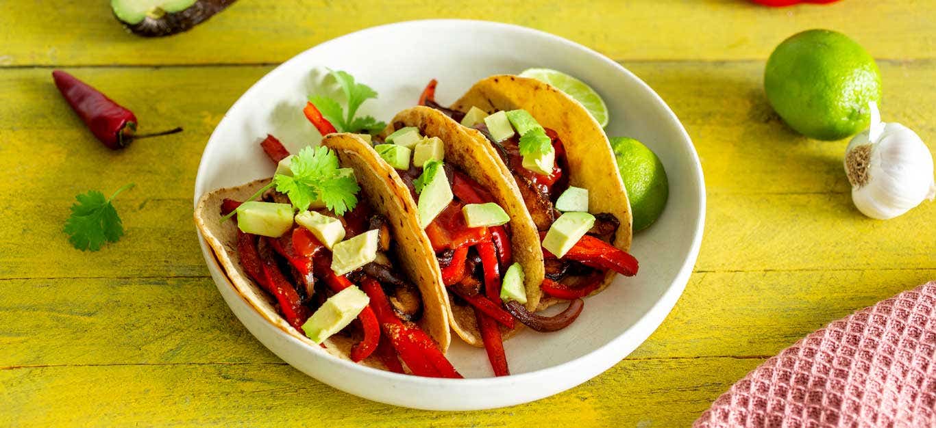 Veggie Fajitas in a white bowl on a yellow table