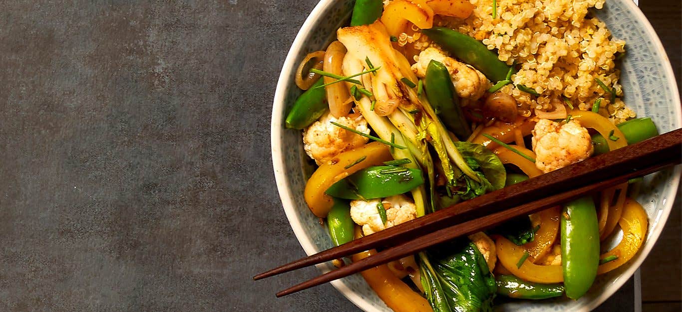 Five-Spice Stir-Fry in a wide-rimmed serving bowl with chopsticks resting across