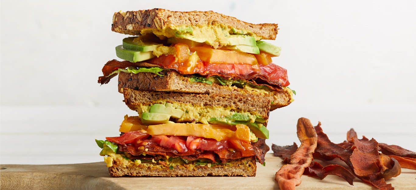 Vegan BLTA with Carrot Bacon on wooden cutting board