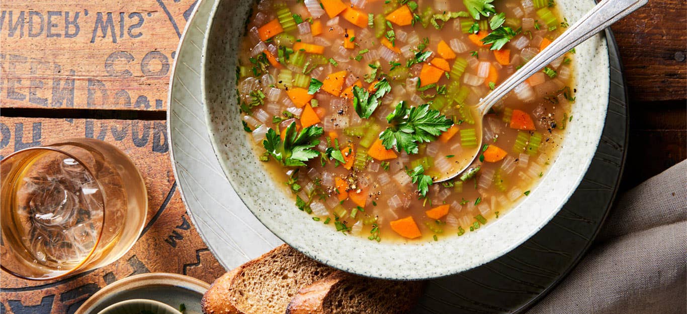 Chestnut soup in a white bowl with a metal spoon and side of dark bread