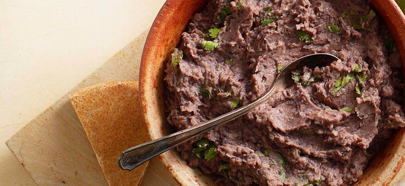 Chipotle Black Bean Dip in a red bowl, with chips on the side