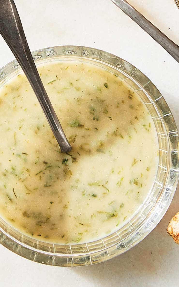 an oil-free vegan ranch dressing shown in a glass with a silver spoon