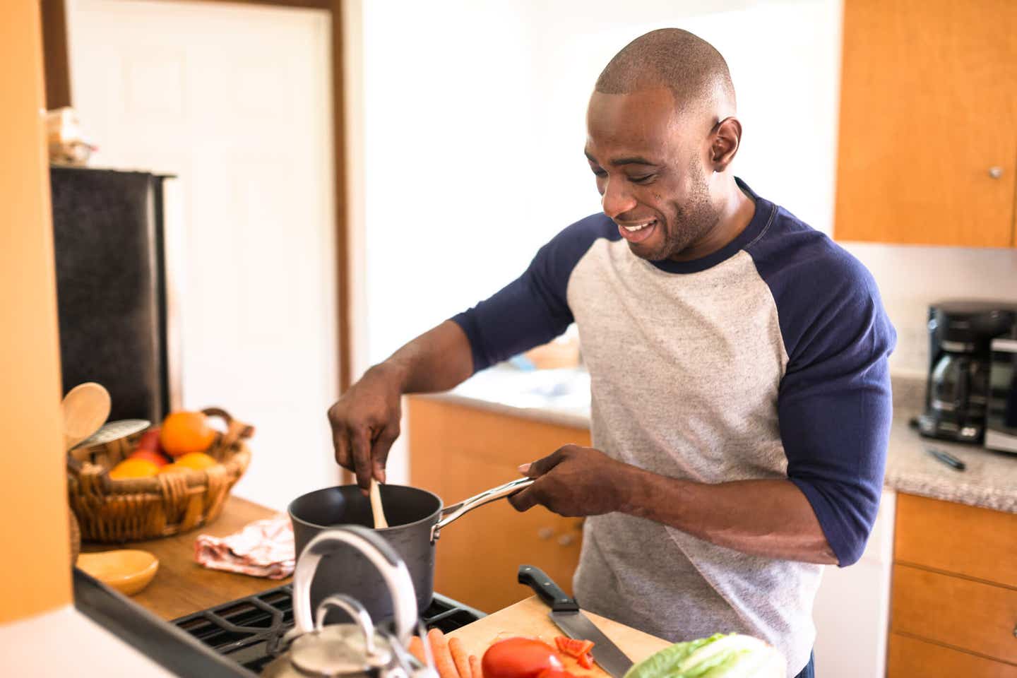 happy man standing on the kitchen and preparing food