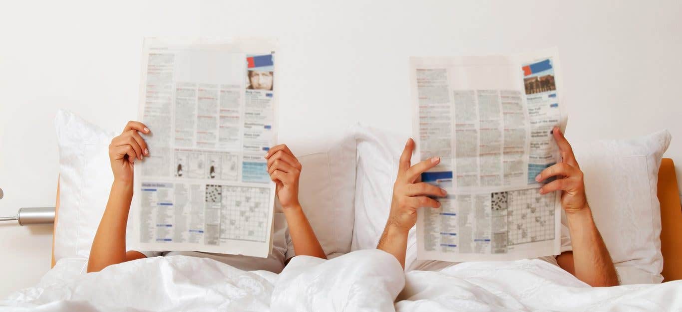 Erectile dysfunction - couple reads newspaper in bed